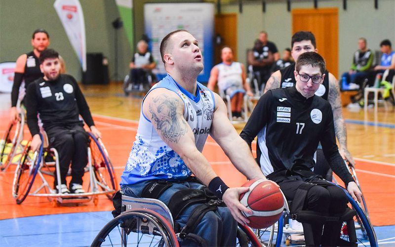 Der Rollstuhl-Basketballspieler Rekanovic von den Sitting Bulls hält den Ball in beiden Händen, blickt zum Korb und bereitet sich auf einen Wurf vor.